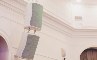 Musical speaker column on a white wall ceiling